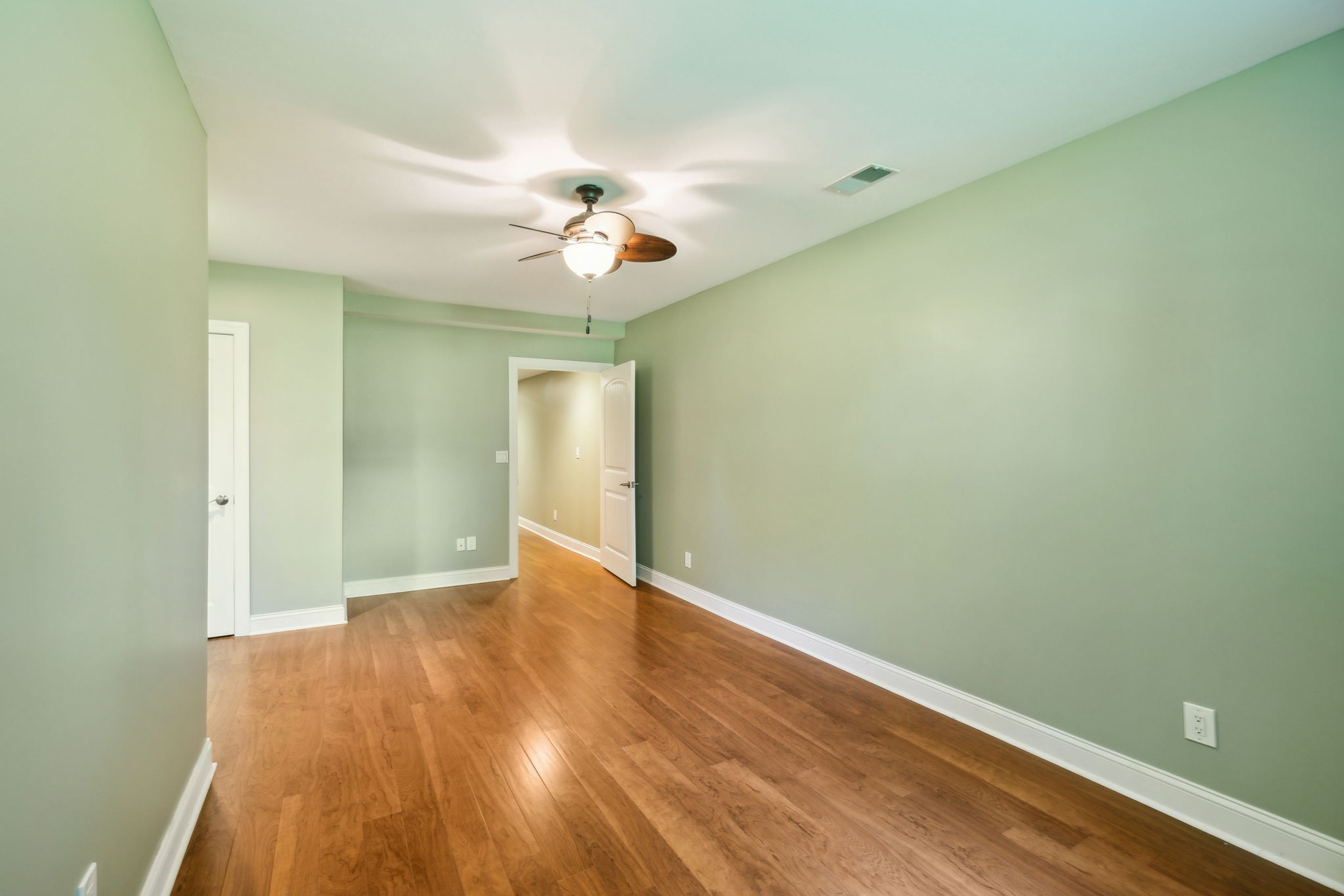 8166 Poplar Creek Road Nashville, TN 37221 - Photo 40 of 63 an empty room with wooden floor and ceiling fan