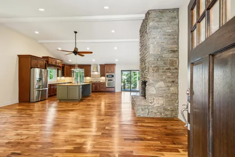 a view of a kitchen with kitchen island a counter top space a sink stainless steel appliances and cabinets
