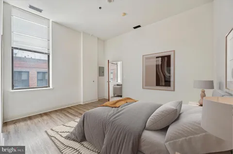 a bedroom with a bed and wooden floor