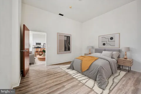 a bedroom with a large bed and a wooden floor