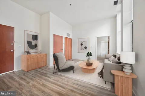 a living room with furniture a rug and white walls