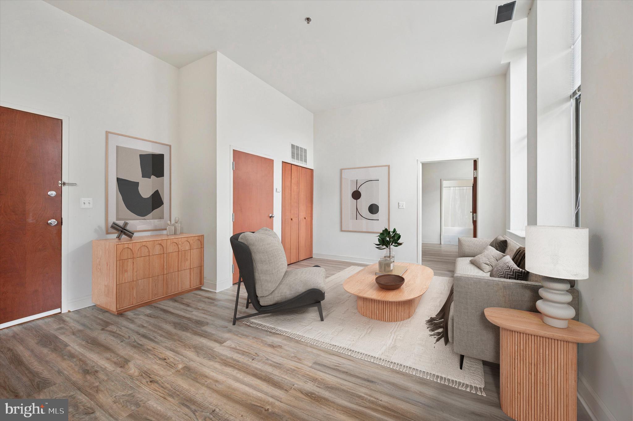 1001 Chestnut Street, Unit 904W Philadelphia, PA 19103 - Photo 2 of 25 a living room with furniture a rug and white walls