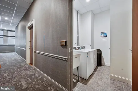 a view of a hallway with white cabinets