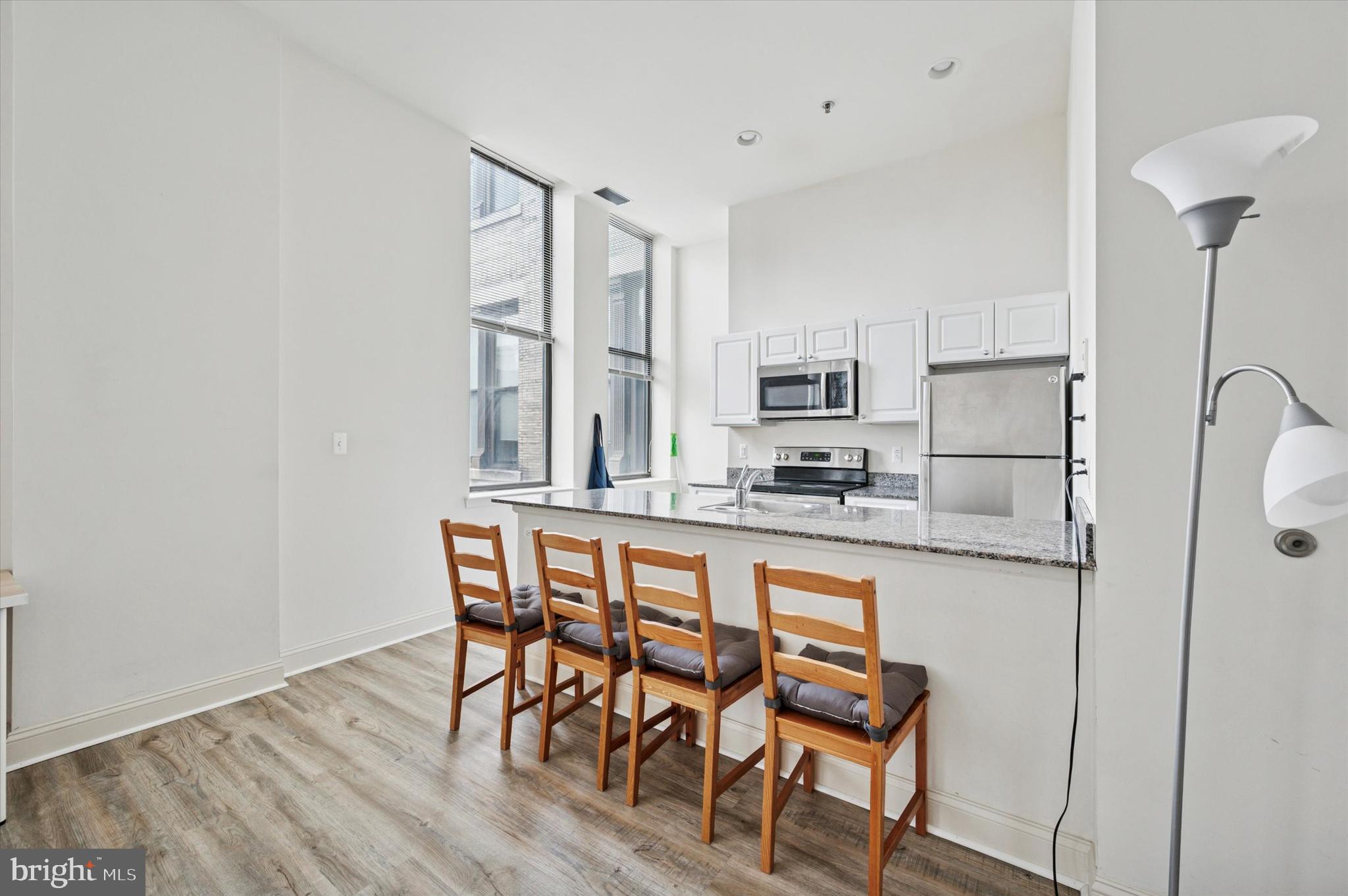 1001 Chestnut Street, Unit 904W Philadelphia, PA 19103 - Photo 9 of 25 a kitchen with stainless steel appliances granite countertop a table chairs stove and granite counter tops