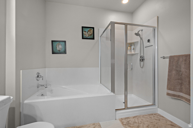 1074 South 750 West Springville, UT 84663 - Photo 16 of 28 White corner soaking tub and glass-enclosed shower with chrome fixtures, recessed lighting, and light gray wall paint