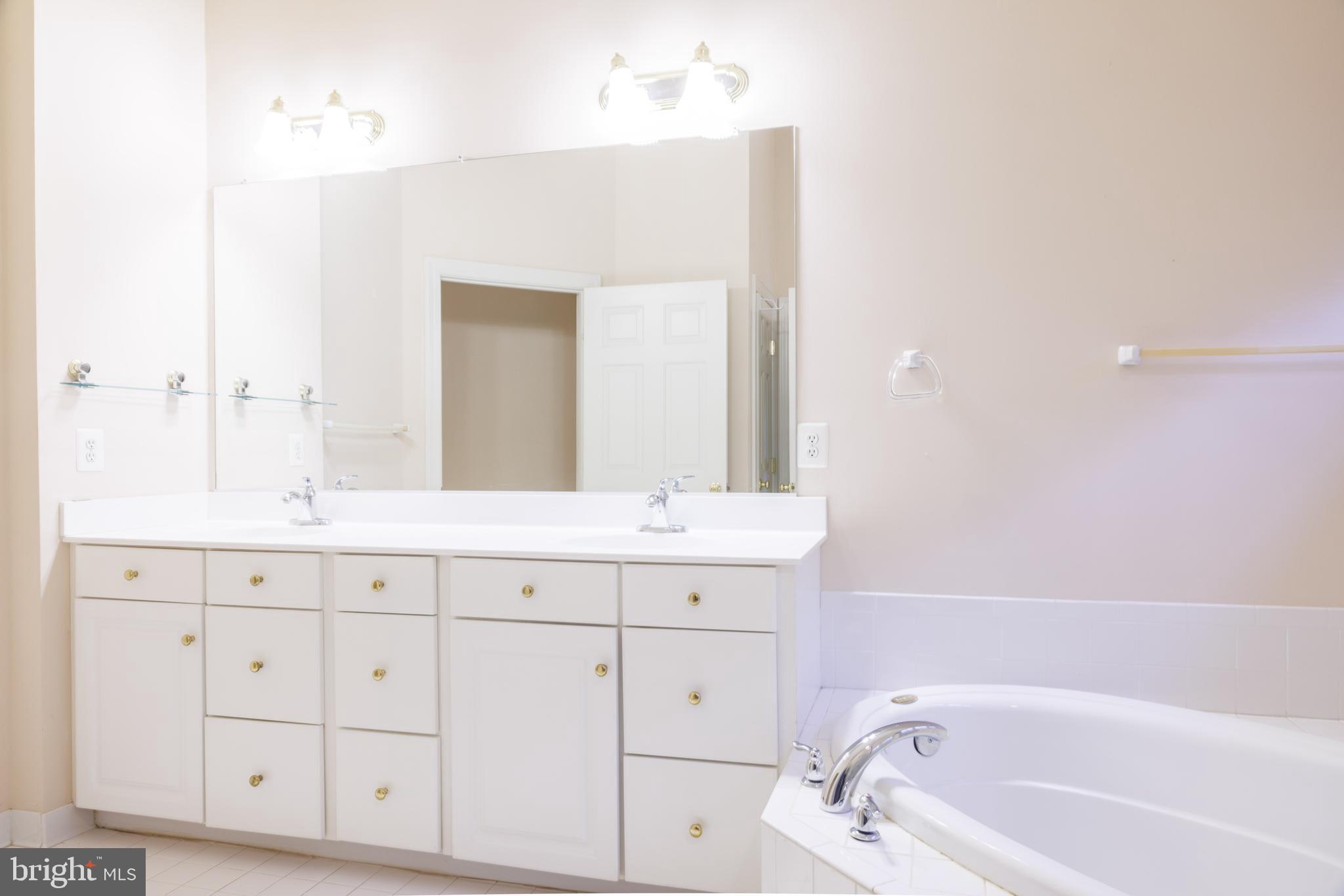 8623 James Creek Drive Springfield, VA 22152 - Photo 37 of 69 a bathroom with a tub sink and mirror