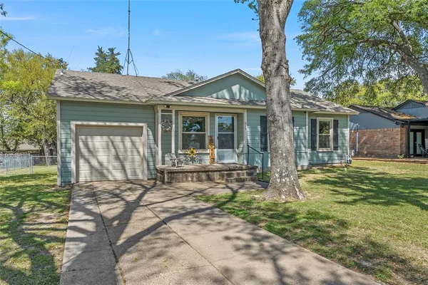 a view of a house with a yard patio and wooden fence