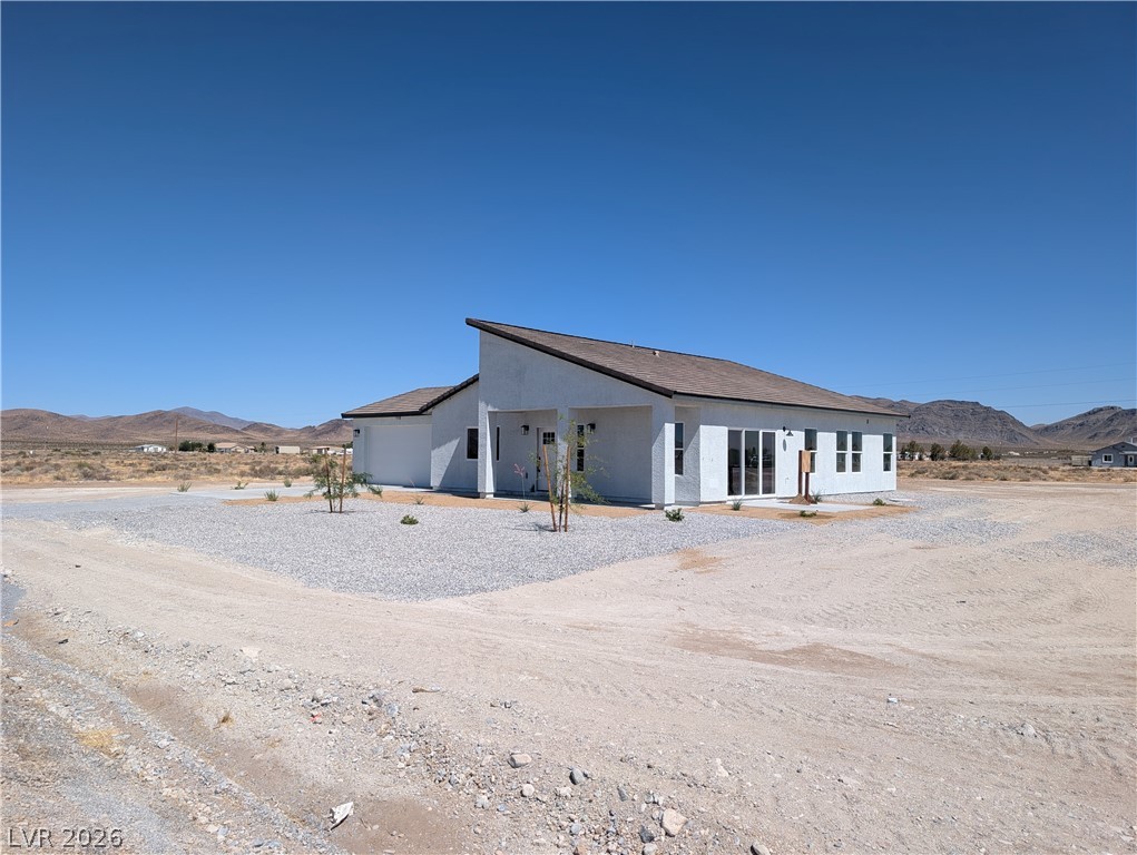 4670 Medicine Man Road Pahrump, NV 89048 - Photo 4 of 36 Modern desert retreat with a sleek roofline against a backdrop of distant mountains.