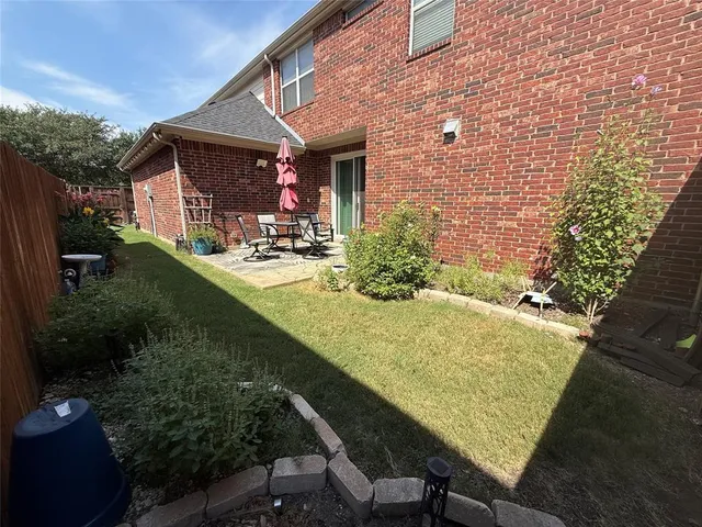 a view of a patio with table and chairs potted plants with wooden floor and fence