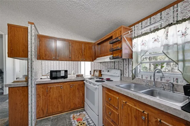 a kitchen with stainless steel appliances a sink a stove and a refrigerator