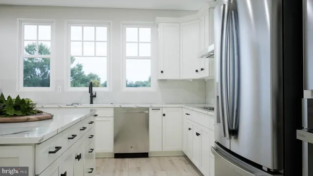 a kitchen with granite countertop white cabinets and a window