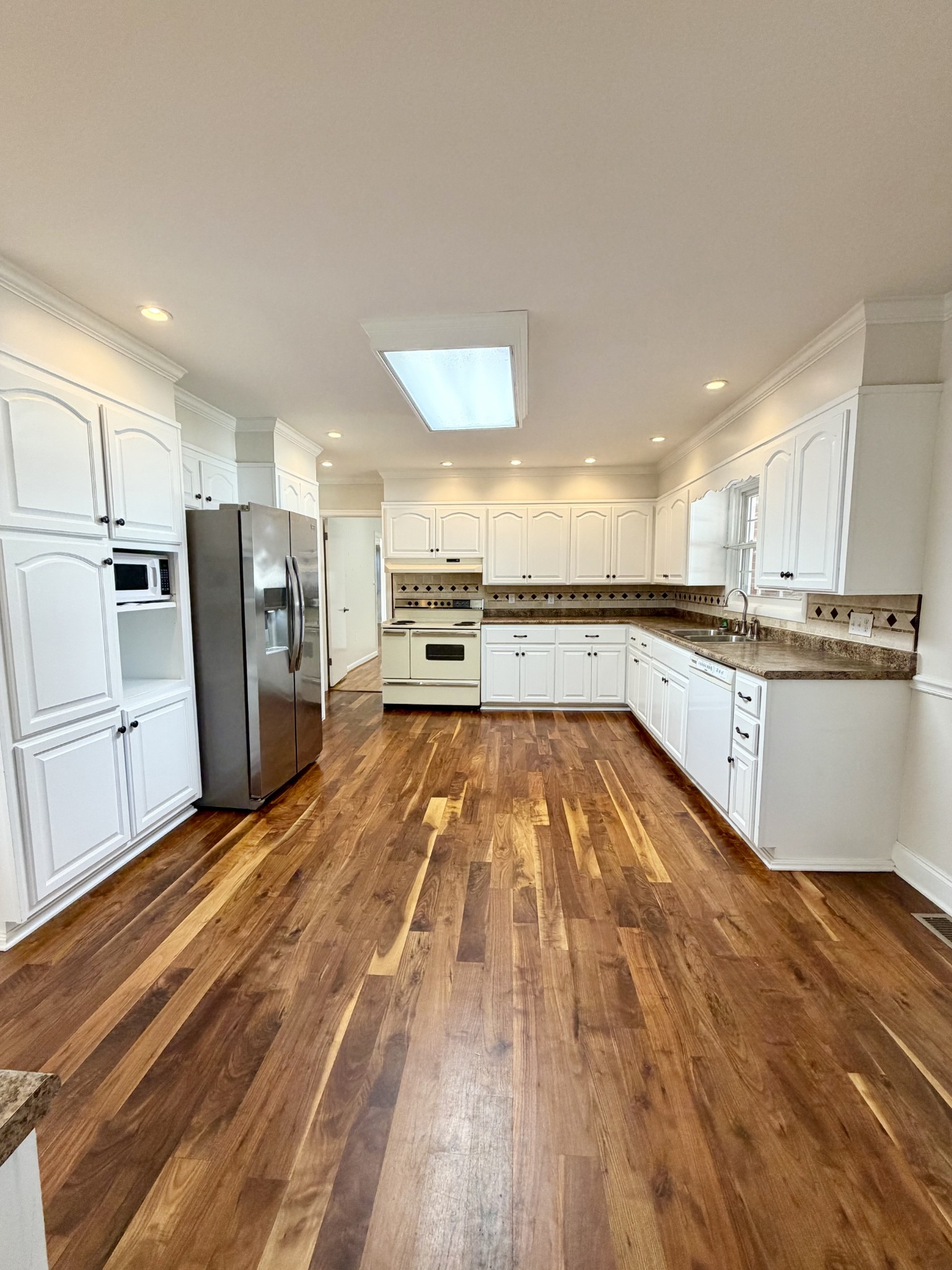 422 7th Street Lawrenceburg, TN 38464 - Photo 8 of 25 a large kitchen with stainless steel appliances granite countertop a large counter top and a stove top oven with wooden floor