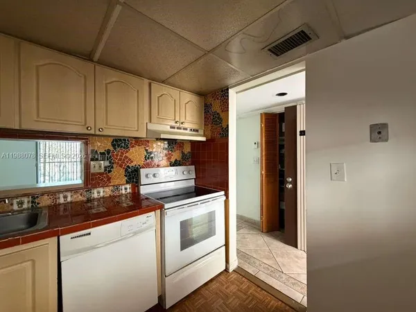 a kitchen with cabinets appliances a sink and a counter top space