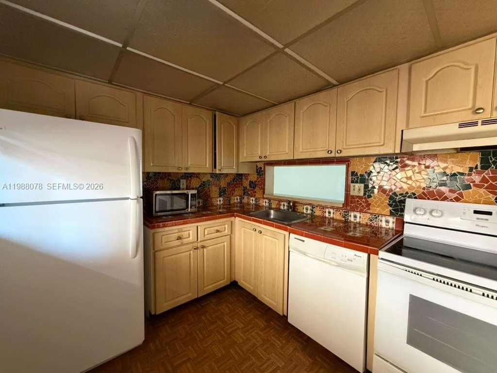 8420 Southwest 133rd Avenue Road, Unit 309 Miami, FL 33183 - Photo 20 of 22 a kitchen with cabinets appliances a sink and a counter top space