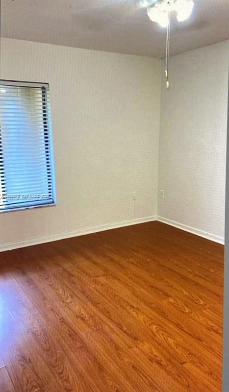 8420 Southwest 133rd Avenue Road, Unit 309 Miami, FL 33183 - Photo 6 of 22 a view of an empty room with wooden floor and a window