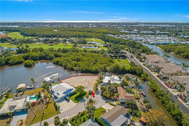 an aerial view of a city with lots of residential buildings ocean and mountain view in back