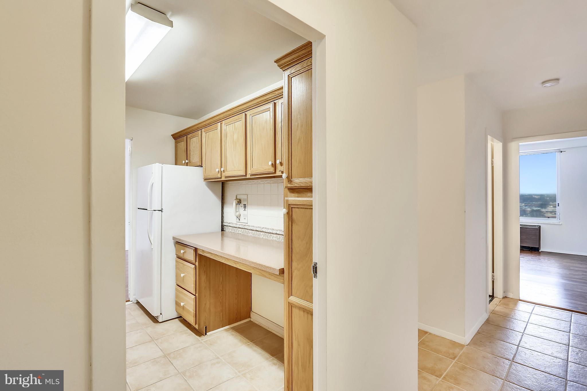 9701 Fields Road, Unit 1604 Gaithersburg, MD 20878 - Photo 2 of 30 a view of a refrigerator in kitchen and wooden floor