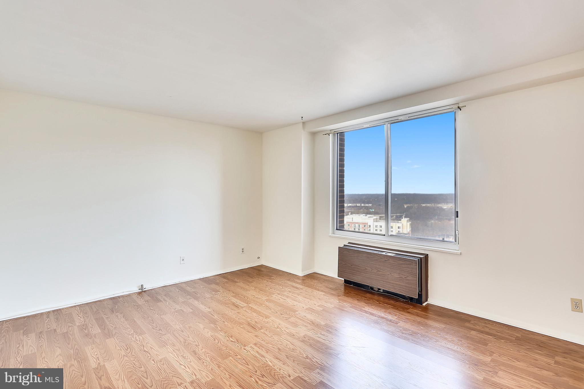9701 Fields Road, Unit 1604 Gaithersburg, MD 20878 - Photo 14 of 30 an empty room with a fireplace and wooden floor