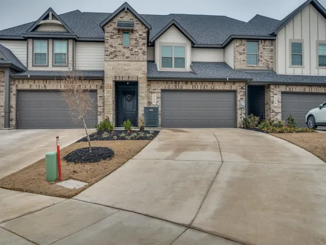 a front view of a house with yard and parking space