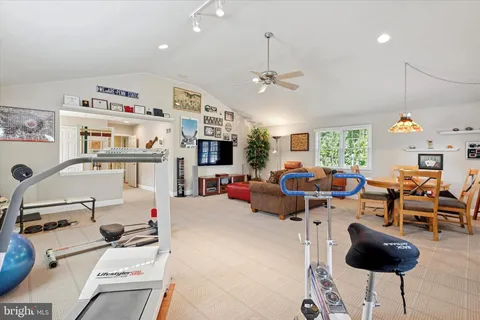 a dining room with furniture a chandelier and a flat screen tv