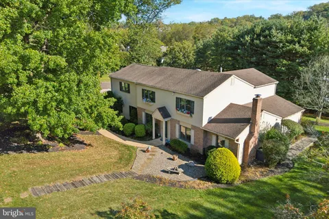 an aerial view of residential houses with outdoor space and trees