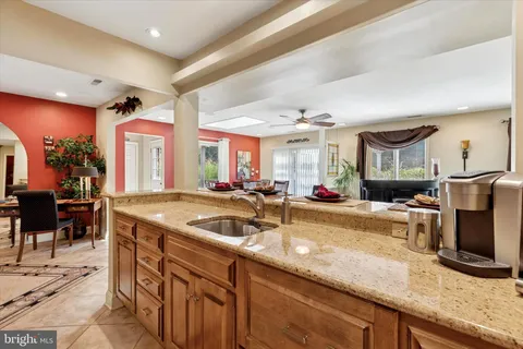 a view of a kitchen counter top space with stainless steel appliances granite countertop sink and wooden floor