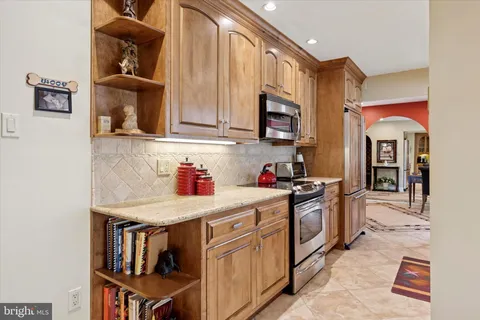 a kitchen with stainless steel appliances granite countertop a stove and cabinets