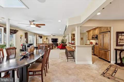 a view of a dining room and livingroom with furniture wooden floor a rug a flat screen tv