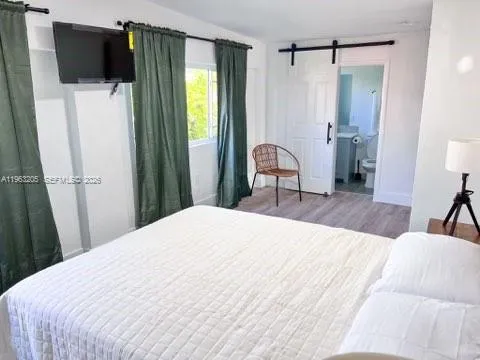 a bedroom with a bed and flat tv screen