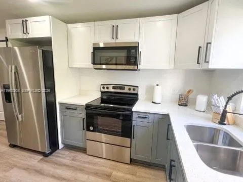 a kitchen with stainless steel appliances granite countertop a refrigerator stove and sink