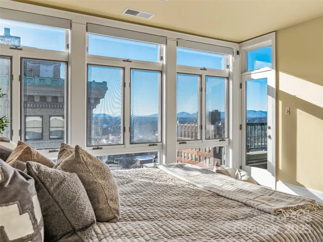 a spacious bedroom with a bed and a large window