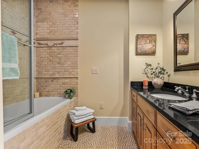 a bathroom with a granite countertop sink a toilet a mirror and shower