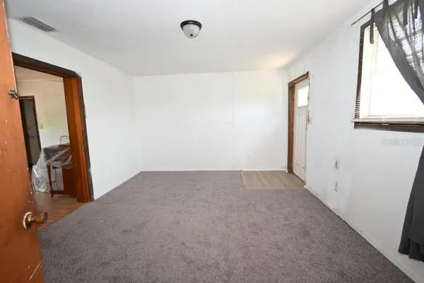 a view of an empty room and a window