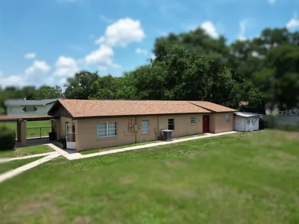 a view of a house with a yard and sitting area