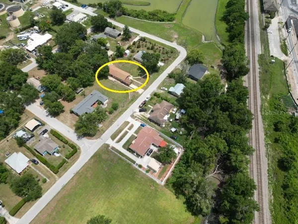 an aerial view of a house a yard and trees
