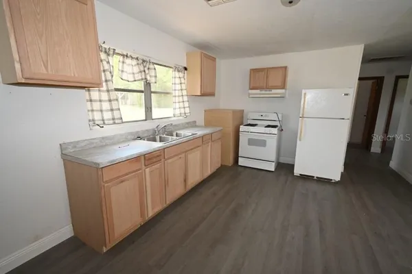 a kitchen with white cabinets sink and white appliances