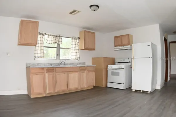 a kitchen with white cabinets and white appliances