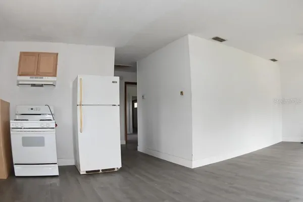 a view of a refrigerator in kitchen and white cabinets