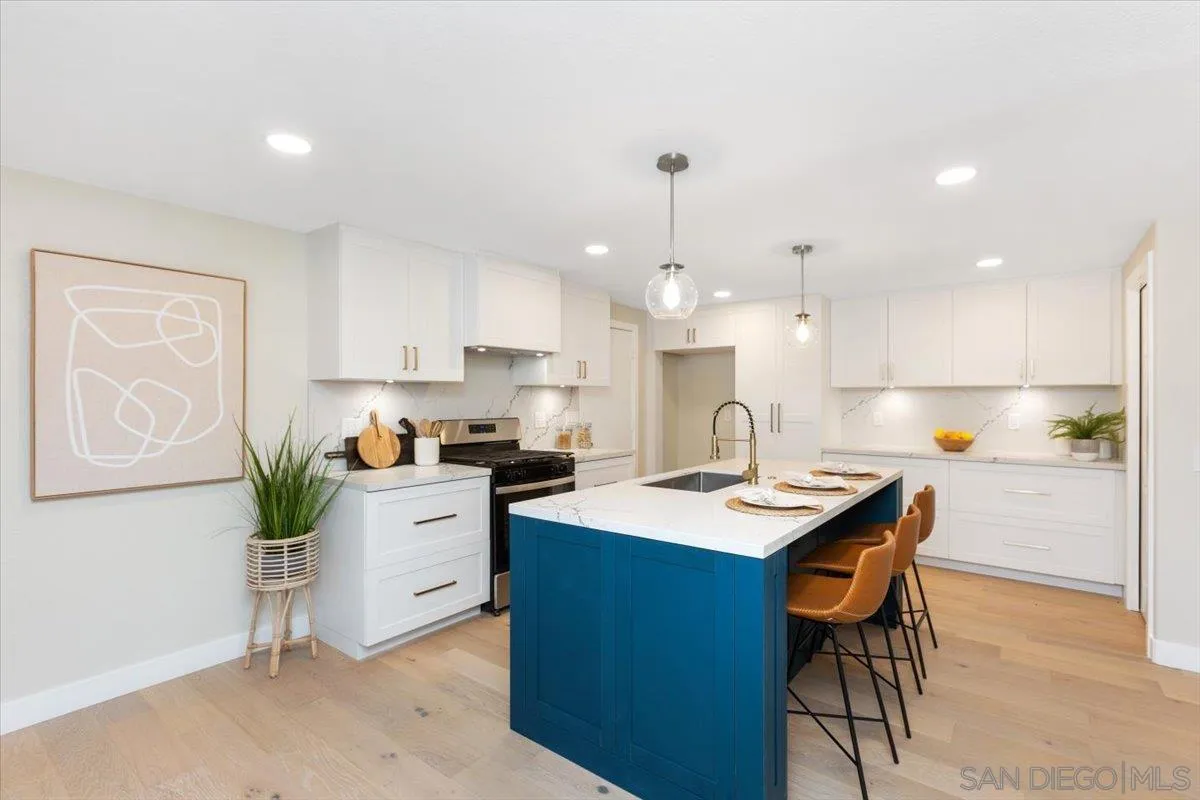 4692 Adra Way Oceanside, CA 92056 - Photo 7 of 51 a kitchen with stainless steel appliances kitchen island granite countertop a sink a stove a refrigerator and white cabinets with wooden floor