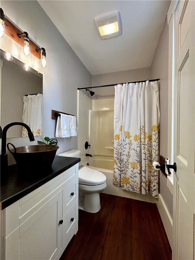 2086 Scheyhing Road Lewisburg, OH 45338 - Photo 16 of 29 This bright bathroom features a vanity, a toilet, a shower, and dark hardwood flooring.