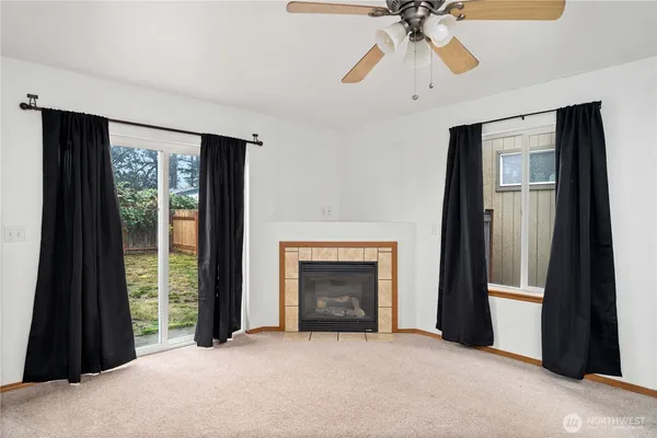 a view of an empty room with window and a fireplace