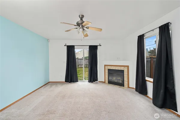 a view of an empty room with a fireplace and a window