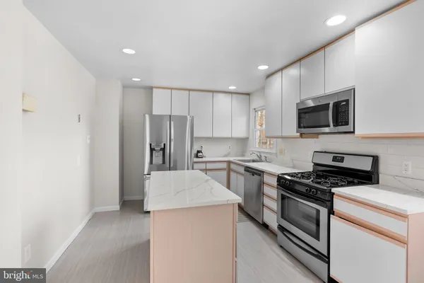 a kitchen with stainless steel appliances a refrigerator stove and microwave