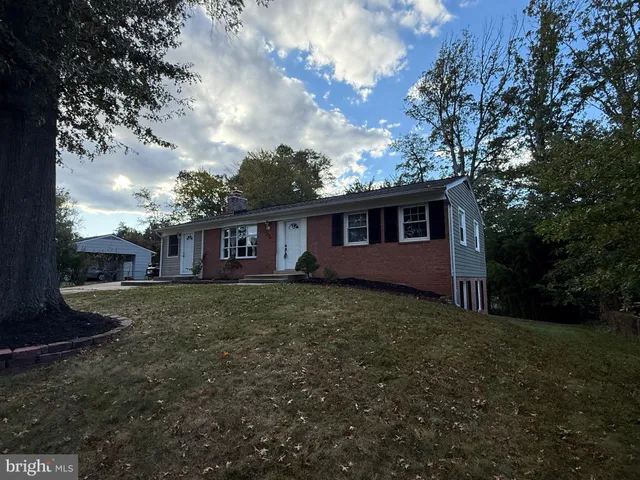 a view of a yard in front of a house with large tree