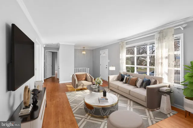 a living room with furniture a flat screen tv and a large window