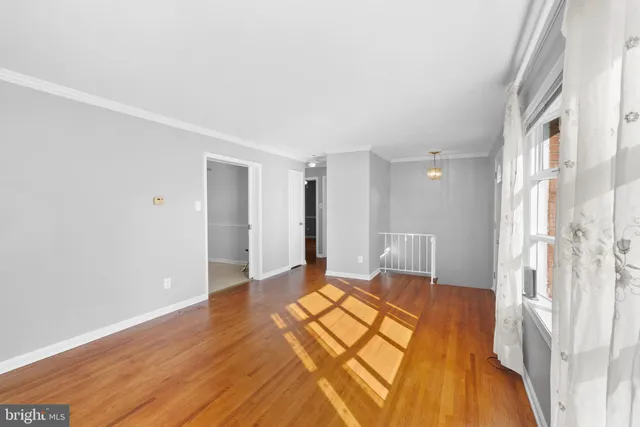 a bedroom with a bed and a walk in closet with wooden floor