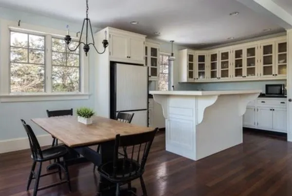 a kitchen with a table chairs refrigerator and cabinets