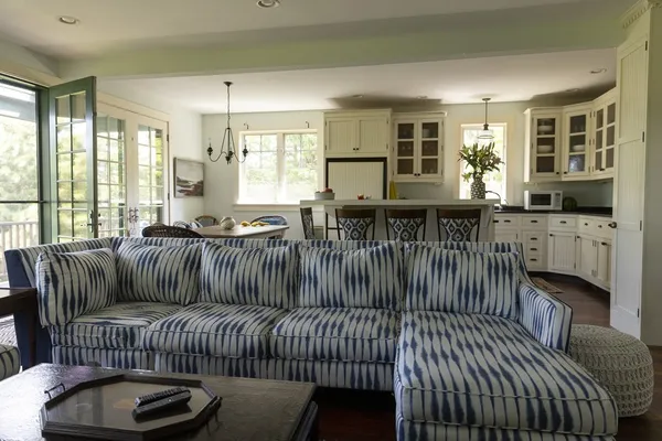 a living room with furniture a fireplace and large windows
