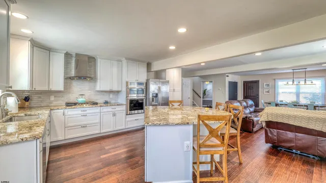 a large kitchen with cabinets table and chairs
