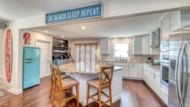 a kitchen with refrigerator a stove and wooden floor